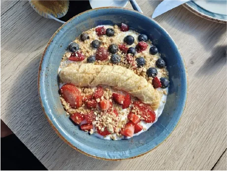 Bol con plátano, fresas, arándanos, frambuesas y frutos secos en Awen Gastrobar