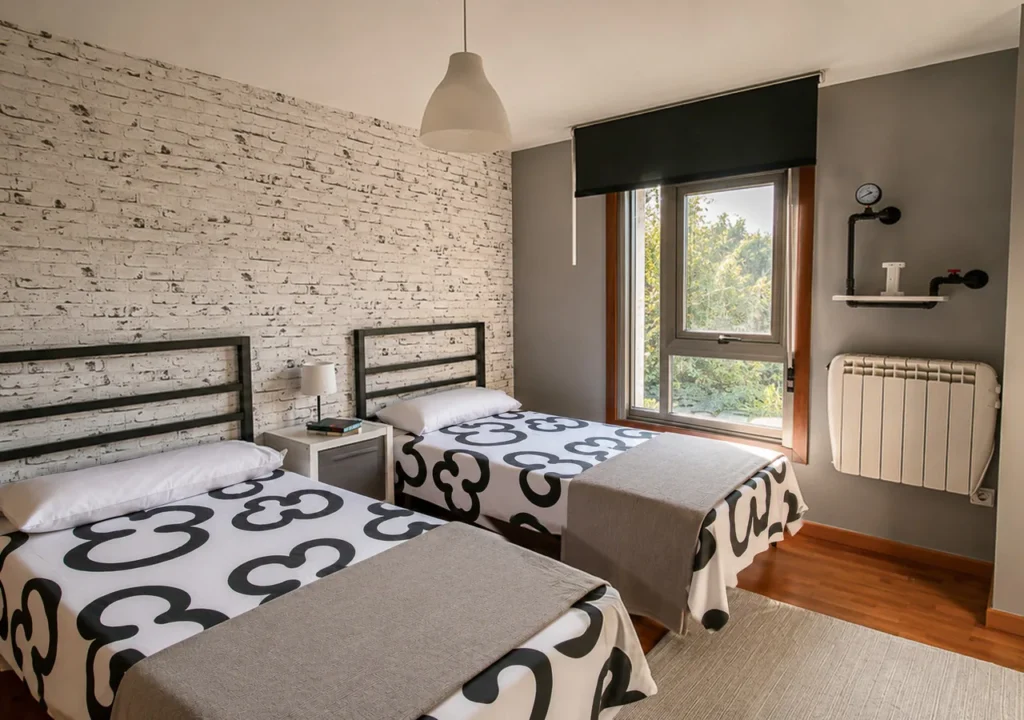 Dormitorio luminoso con dos camas individuales en O Igrexario Vacacional