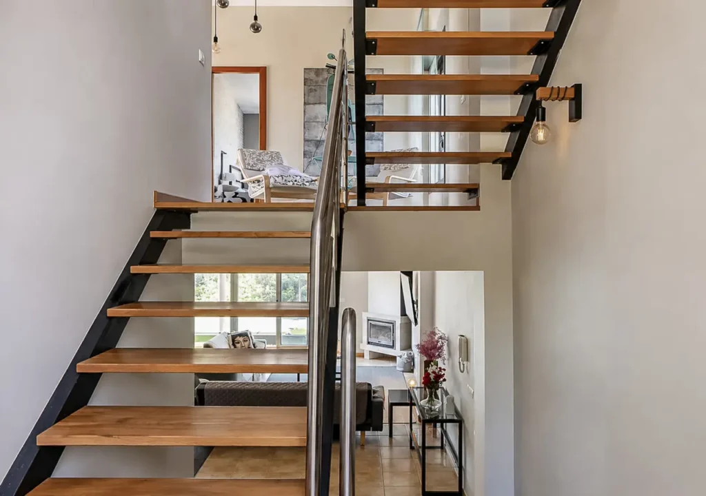Escaleras interiores de madera que conectan las plantas de O Igrexario Vacacional
