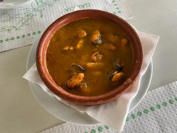 Mejillones en salsa servidos en una cazuela de barro en Tapería Peralta