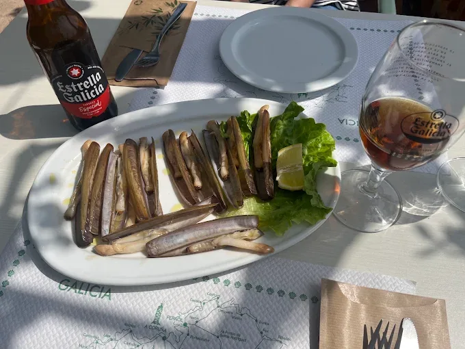 Ración de navajas a la plancha con limón servida en Tapería Peralta de Aldán