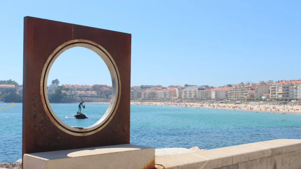 Playa de Silgar y escultura de la Madama vistas desde el paseo marítimo de Sanxenxo