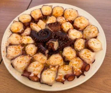 Plato de pulpo con patatas, aceite de oliva y pimentón servido en Bar Pinela