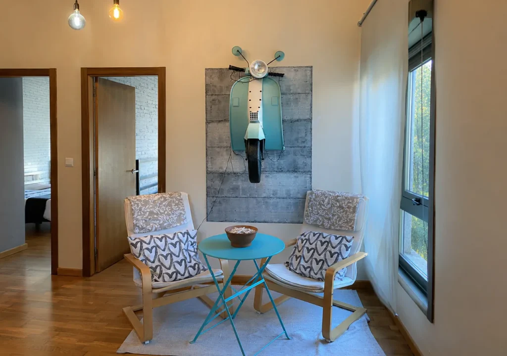 Rincón de descanso con dos sillones y una moto vintage decorativa en O Igrexario Vacacional