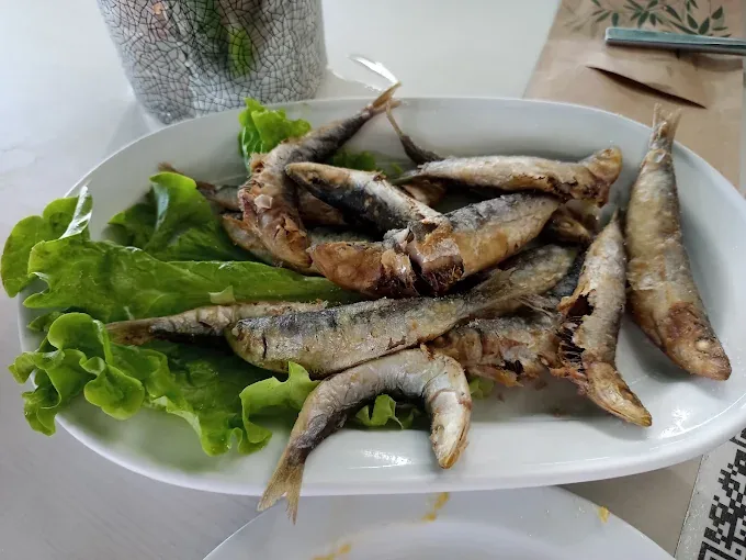 Ración de pequeñas sardinas fritas acompañadas de lechuga en Tapería Peralta