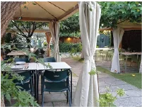 Terraza exterior ajardinada con mesas de Bar Pinela en Aldán