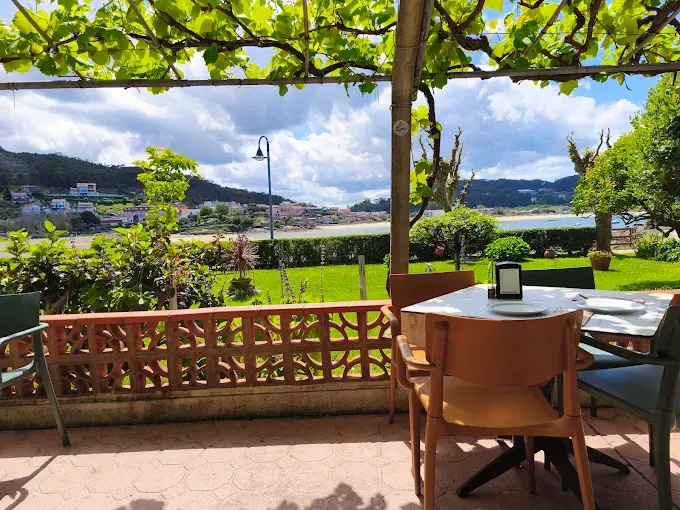 Terraza de Tapería Peralta con jardín y vistas a la ría de Aldán